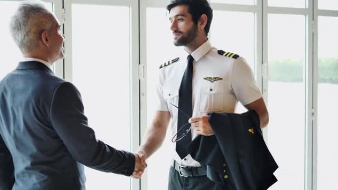 商人和飞行员一起在机场航站楼交谈。