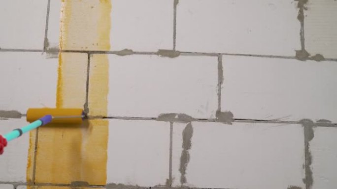 橙色墙壁底漆。用橙色底漆灌注混凝土砌块墙。