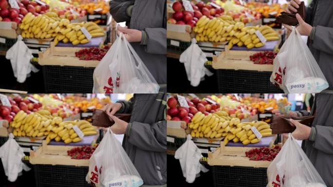 女售货员将橘子放在用钱付款的买家的袋子里