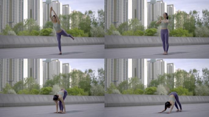 年轻亚洲女子在城市公共广场练习瑜伽