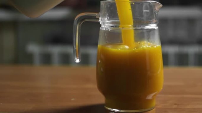 将橙汁或南瓜汁从平底锅倒入玻璃罐中