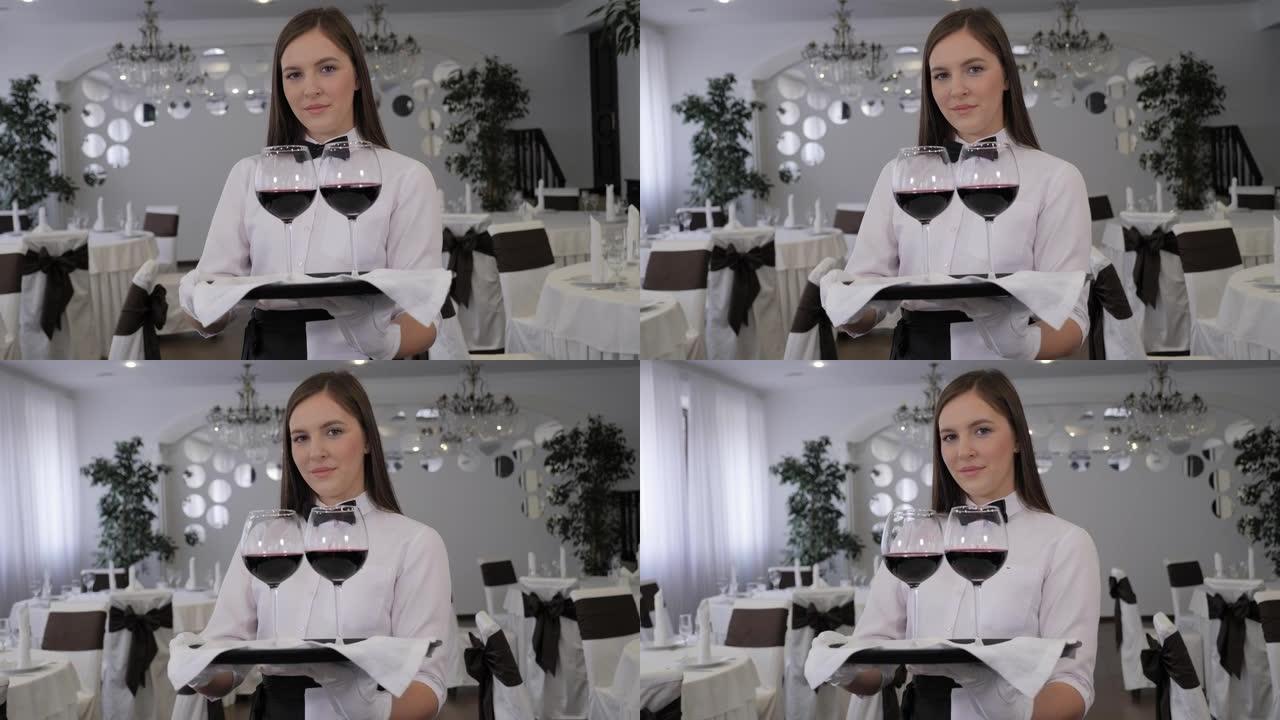 一家餐馆的女服务员拿着一个装有红酒的托盘。