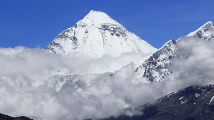 时光倒流的云在山谷中盘旋，远处是雪峰。野马、尼泊尔、安纳普尔纳