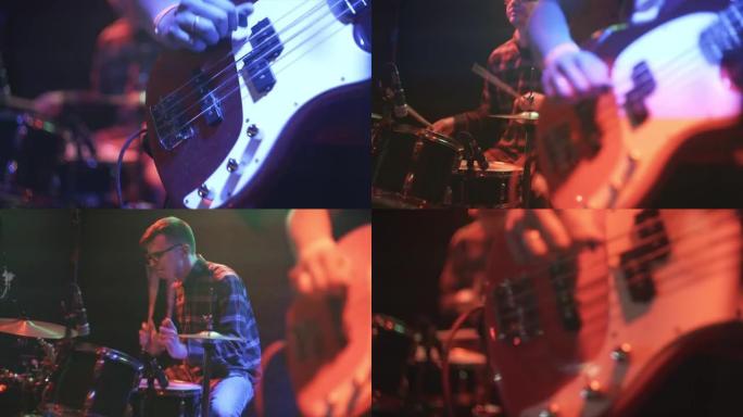 吉他手在夜间的现场表演中在摇滚乐队中演奏电吉他，在彩色聚光灯下聚焦回到背景中的鼓手