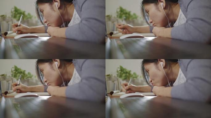 一名亚洲妇女在网上学习时，在桌子上展示了下巴的最大波隆。