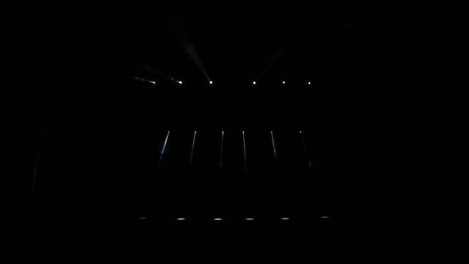 舞台灯。黑暗中的投影仪。聚光灯穿过黑暗。
