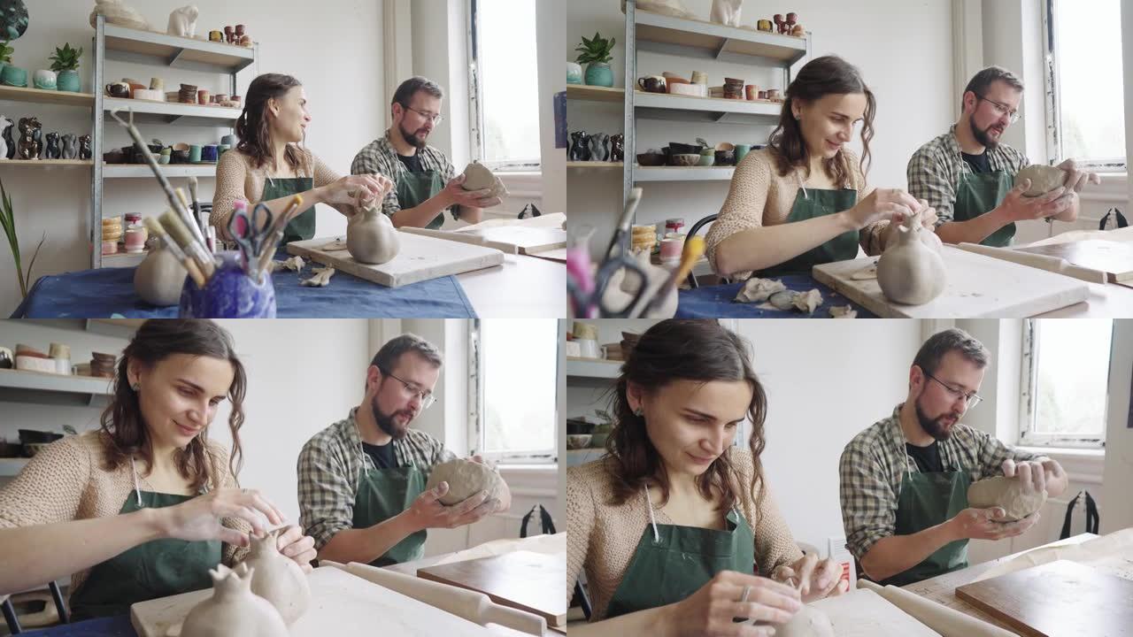男人和女人陶艺家在他们的工作室里一起工作