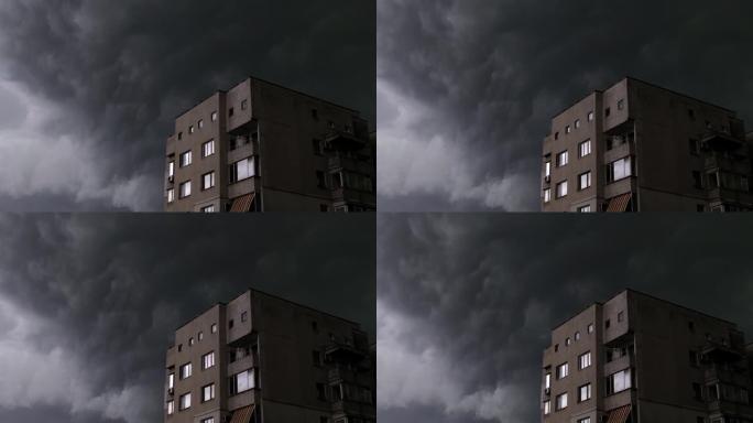 快速移动的喜怒无常的黑暗暴风云与强风在城市与建筑在一边。即将来临的风暴