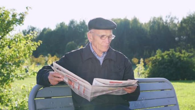 戴着帽子和眼镜的养老金领取者读大报纸