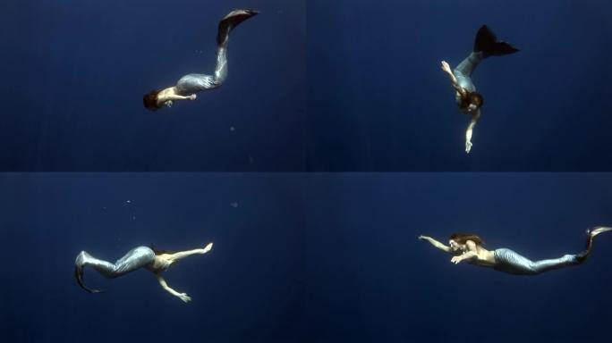 蓝色背景的年轻女孩模特水下美人鱼服装在红海摆姿势。