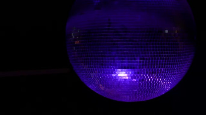 旋转的镜面球迪斯科球的特写镜头，彩色灯光反射。