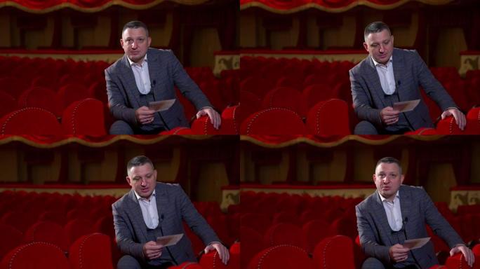 穿着服装的人读剧本。演员在空剧院在红色椅子上排练的中等镜头。表演生活方式。