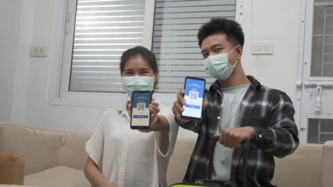 男女夫妇准备旅行，在智能手机上展示数字疫苗健康护照证书应用程序