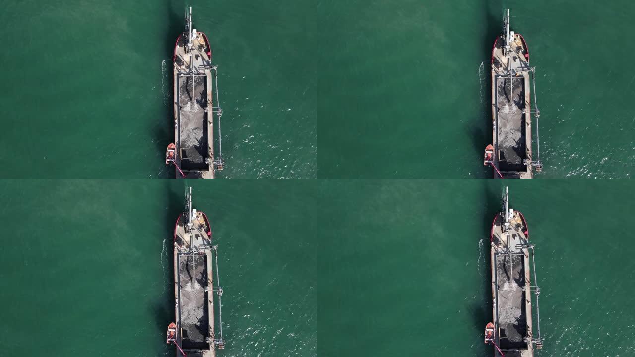 大型工业疏浚船将吨砂泵入船舶储存区，用于海岸补给维护项目的独特特写视图。