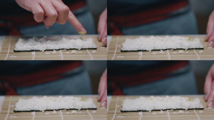 日本厨师在做寿司maki时将芥末放在米饭上