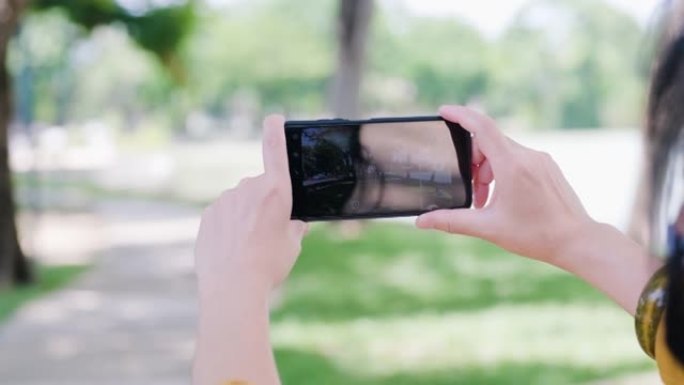 女人使用手机和增强现实应用程序在公园预报天气