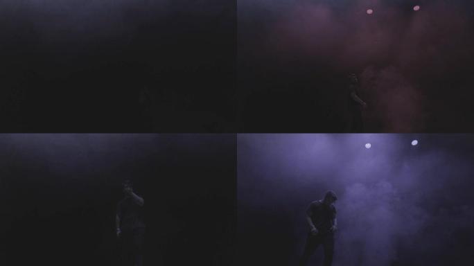 一名歌手年轻人的表演出现在黑暗背景下的蒸汽烟雾中