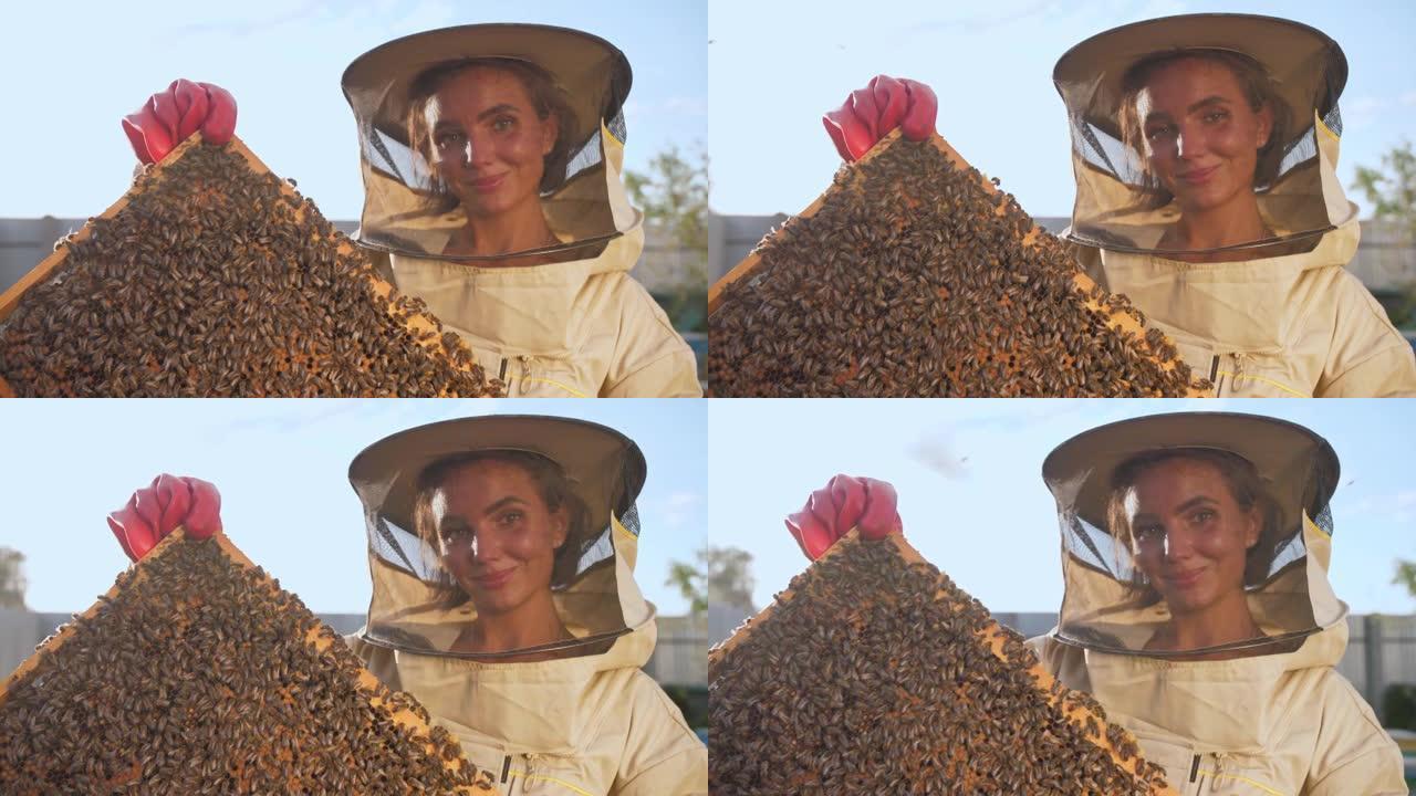 一个穿着防护服的女养蜂人带着蜂巢里的蜂蜜