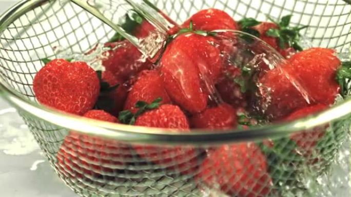 超级慢动作在滤器中的草莓上滴水。以1000 fps的速度在高速相机上拍摄