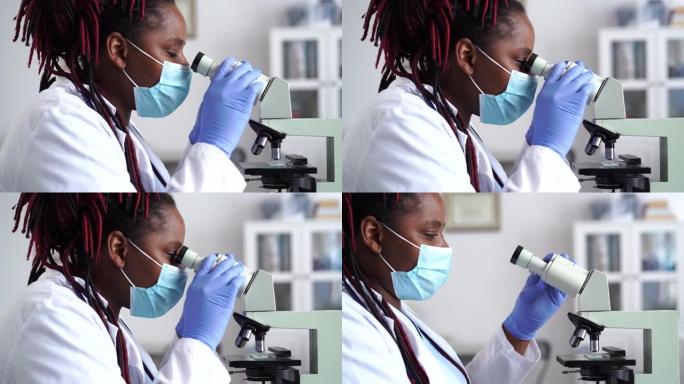 在实验室中使用显微镜的非洲女科学家工人的侧视图的4k视频