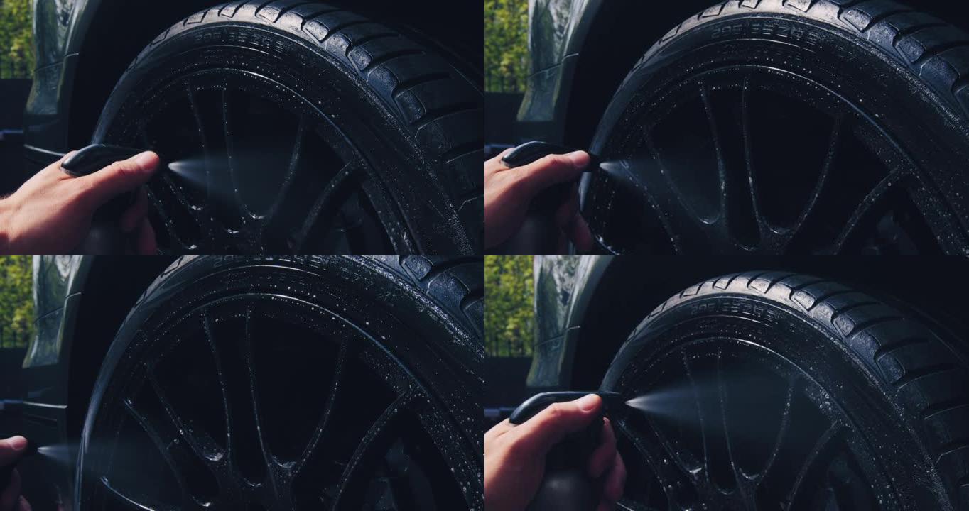 员工在洗车工作。在汽车维修中使用泡沫和水清洗车轮，特写镜头。汽车细节概念