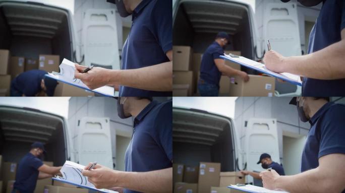 快递员卸下包裹和检查文件的视频。用8k的红氦相机拍摄。