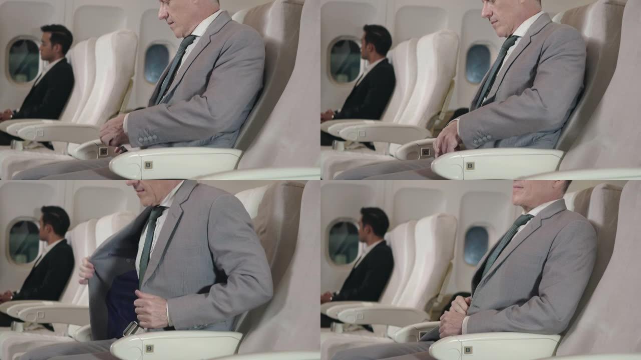 老年商人乘客在飞行途中在飞机上系好安全带