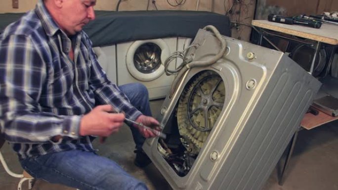 技术人员在洗衣机中安装了一个新零件。