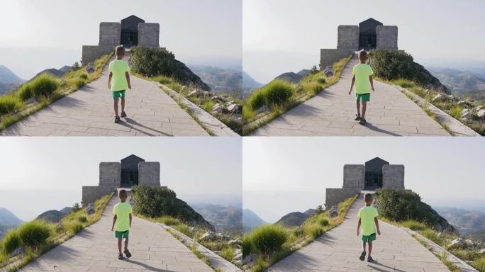 5岁可爱的小男孩走在石路顶上看黑山美丽风景的背景图