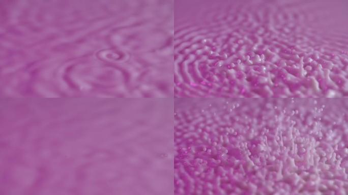 振动和共振。声波在牛奶紫色表面的分布。当被不同频率的振动激发时，乳状流体的圆圈和波纹。慢动作。特写