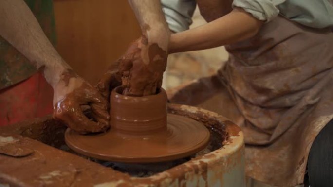 陶器班，女人在轮子上做陶罐。脏手特写，雕刻粘土陶器大师班陶器培训