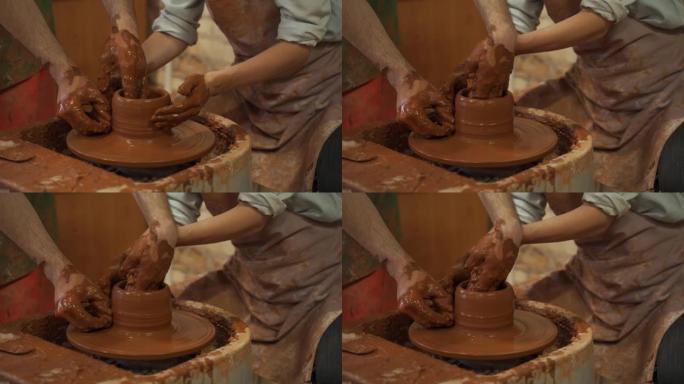 陶器班，女人在轮子上做陶罐。脏手特写，雕刻粘土陶器大师班陶器培训