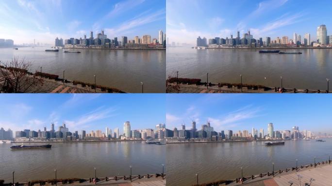 晴天在黄浦江上航行的货船，外滩建筑背景，4k快速镜头，宽镜头b翻盘拍摄视频。