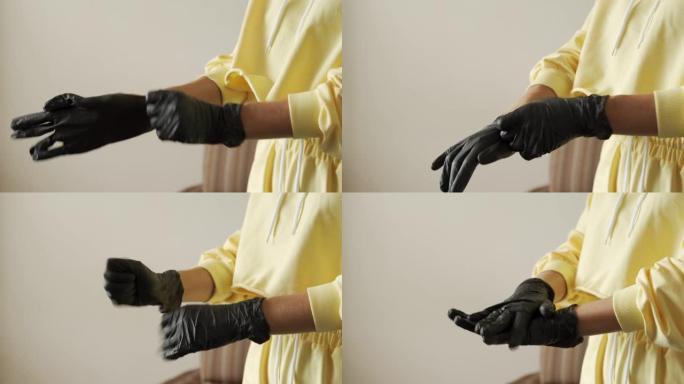 特写的年轻女子双手戴上黑色医用丁腈手套。病毒保护