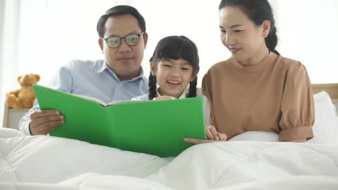 父母在床上给女儿读书