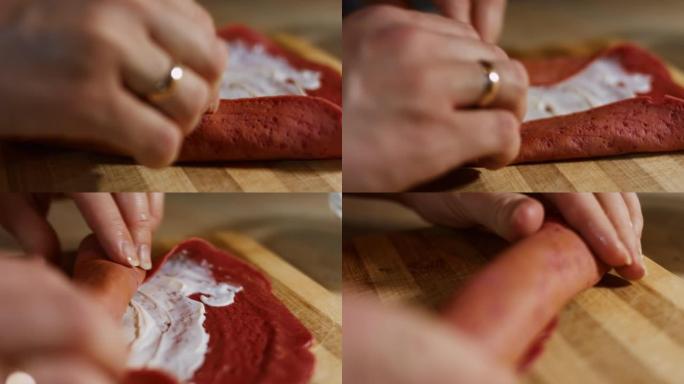 薄薄的美味彩色煎饼。女人的手将鲑鱼片放在木板上涂上奶油奶酪的红色煎饼上的宏观视图。滚动煎饼。4k视频