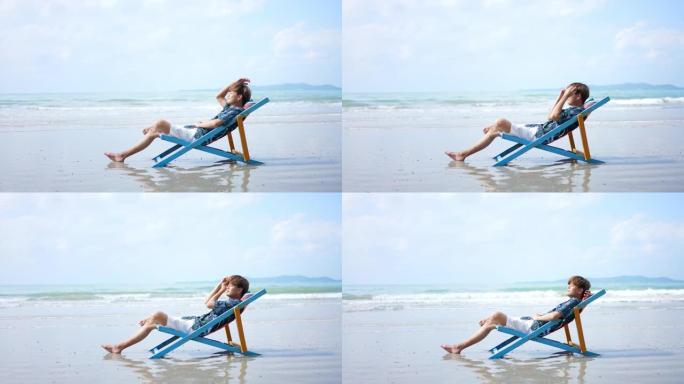 夏季晴天，亚洲人在海滩上的沙滩椅上休息。