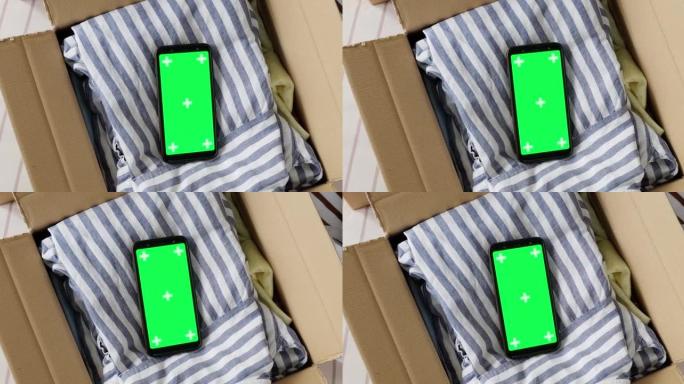 手机绿屏模型的俯视图，装在旧衣服的盒子里。