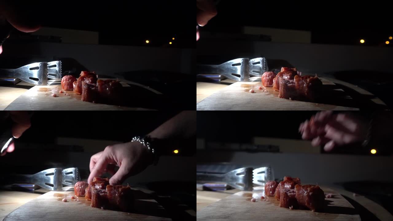 香肠大块的特写镜头在桌子上蒸，并用手抓住晚上在4k吃饭