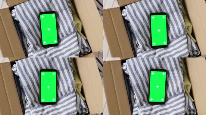 手机绿屏模型的俯视图，装在旧衣服的盒子里。