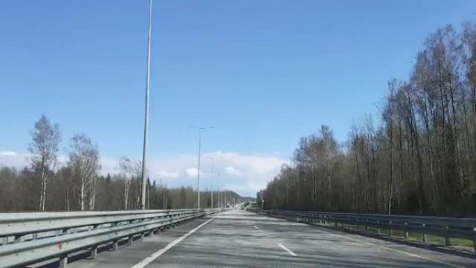 时间圈。在阳光明媚的天气中，通过在圣彼得堡莫斯科高速公路上行驶的汽车的挡风玻璃观看