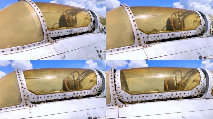 军事战斗机飞行员驾驶舱的特写镜头。玻璃上可见裂纹，随着年龄的增长，裂纹已变成黄色。退役的军事装备。飞