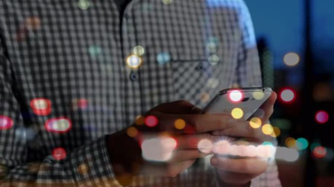在大街上使用智能手机的五颜六色的bokeh灯对着男人的中间部分