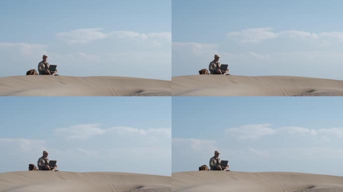 一个男人和他的狗在沙漠里远程工作