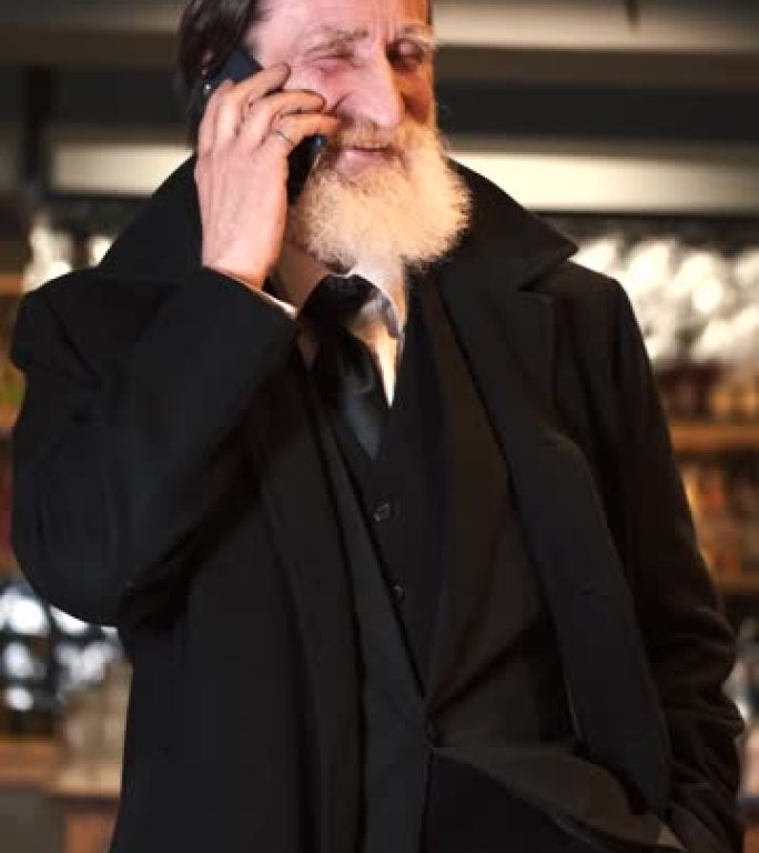 官方风格的老人在餐厅通过电话交谈
