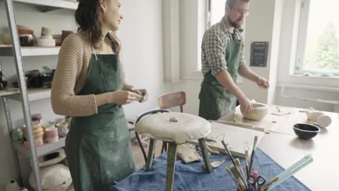男人和女人陶艺家在他们的工作室里一起工作