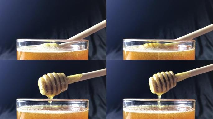 健康有机浓蜂蜜从木制蜜勺蘸，特写。
