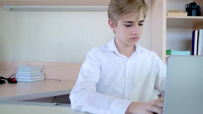 穿着白衬衫的年轻男子少年正在工作，在家庭办公室用笔记本电脑在键盘上打字文本，人和技术概念，在家工作，