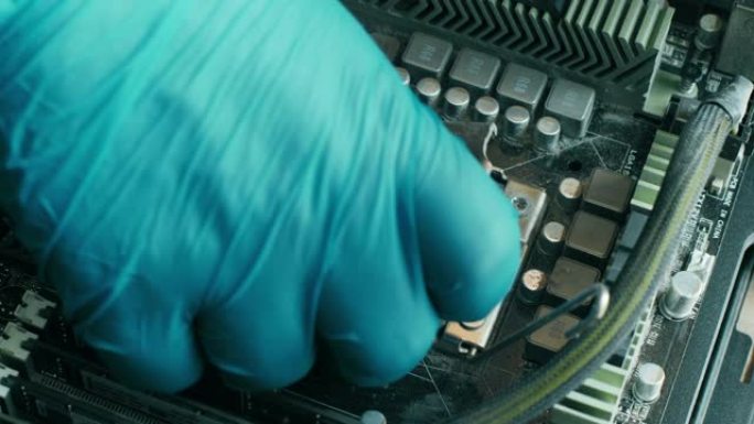 戴着蓝色手套的电子维修技术人员小心地从台式计算机主板上的旧灰尘插座上卸下计算机处理器。个人计算机系统