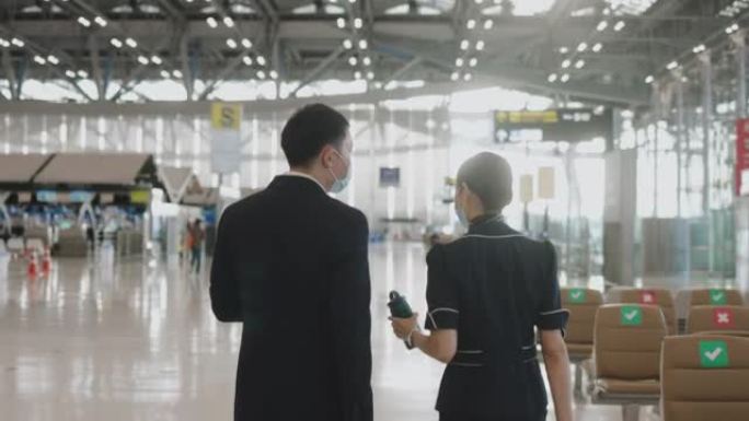 两名乘务员的后视图，带着旅行杯零浪费想法走在一起，然后在机场门口加入另一个队友-股票视频